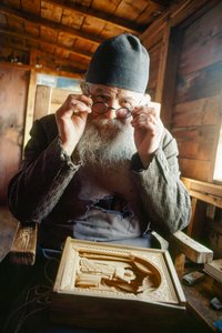 Een meesterbeeldhouwer en orthodoxe priester poseert met zijn werk. Berg Athos, Griekenland. door James L Stanfield