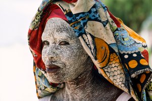 Een vrouw draagt gemalen schorscrème mussiro om haar gezicht te beschermen tegen de zon. Mozambique door James L Stanfield
