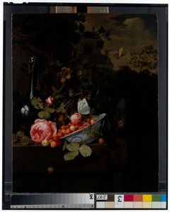 Stilleven met een kom aardbeien, een roos en een fles op een richel, een landschap daarachter