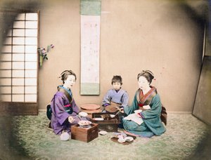 Twee vrouwen en een kind lunchen, zittend op een mat, ca. 1890