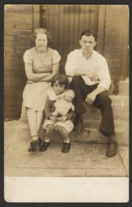 [Familie met pop op stoep]
