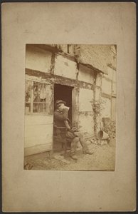 [Zittende man drinkt uit mok in open deuropening].