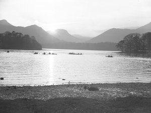 Mensen aan het kanoën op Derwentwater bij zonsopgang of zonsondergang