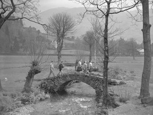 Groep jonge wandelaars loopt over brug door Joseph Hardman