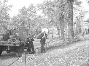 Vrachtwagen op straat met twee kolenmannen die zakken kolen dragen