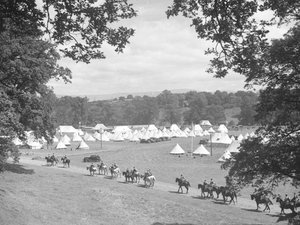 Zicht op meerdere kegelvormige tenten, links lijken mannen in uniform te paard (leger) door Joseph Hardman