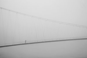Een eenzame wandeling over een mistige brug