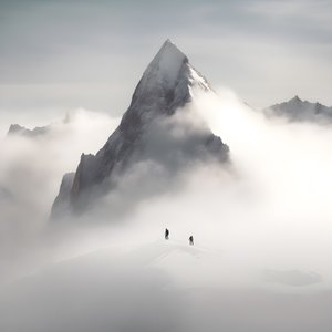 twee mensen aan het skiën boven een bewolkte berg 3