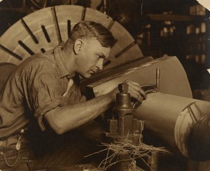 Man met micrometer meet een as tot op een duizendste van een inch.