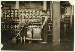 12-jarige doffer Ronald Webb en 7-jarige Frank Robinson, zoon van cardroom baas, die veegt en doft bij Roanoke Cotton Mills, Virginia, 1911 door Lewis Wickes Hine