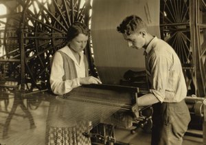 Een jongen en een meisje werken aan een weefgetouw in de Cheney Silk Mills in South Manchester, Connecticut. door Lewis Wickes Hine