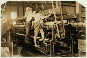 Kleine jongens klimmen op spinmachine om gebroken draden te repareren en lege spoelen te vervangen bij Bibb Mill, Macon, Georgia, 1909 door Lewis Wickes Hine