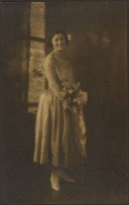 [Portret ten voeten uit van een vrouw die een boeket vasthoudt].