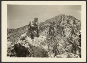 [Man bovenop rotsen].