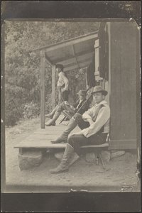 [Mannen zitten op een veranda]. door Louis Fleckenstein