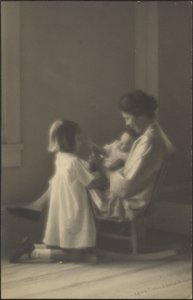 [Moeder in schommelstoel met kinderen] door Louis Fleckenstein