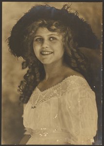 [Portret van een jonge vrouw met kurketrekker krullen].