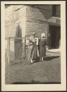 [Twee vrouwen voor het gebouw]. door Louis Fleckenstein