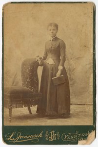 Foto van een vrouw die naast een stoel staat en een boek vasthoudt, laat 19e eeuw door Louis Janousek