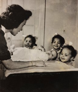 Verpleegster Henry Street helpt drie Afro-Amerikaanse meisjes in Harlem, New York City door Luigi Leoni