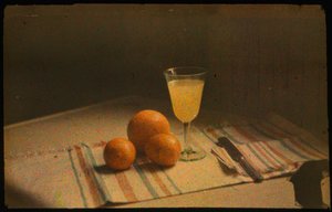 Stilleven kleurenfoto van verse sinaasappels en een glas sinaasappelsap