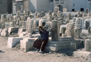 Jemenitische man reciteert de Koran op een begraafplaats met graven in Sayun, Hadramawt, Zuid-Jemen door Lynn Abercrombie