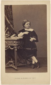[Ongeïdentificeerd klein meisje staat met haar elleboog op een gesloten boek op een tafel]. door Mayer and Pierson
