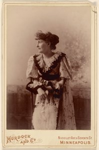 [Ongeïdentificeerde vrouw in profiel, leunend op een stoel, met een veren waaier]. door Murdock and Company