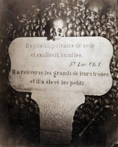 De beenderhuizen van de catacomben van Parijs. Peter met een citaat uit Hoofdstuk 1 van het Evangelie van Sint Lucas (Deposuit potentes de sede et exaltavit humiles. In het Frans: Hij wierp de groten omver en verhief de kleinen)