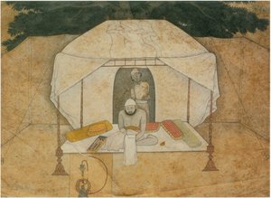 Balwant Singh zittend schrijvend op een veldbed