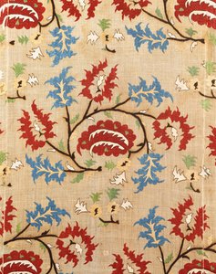 Detail van een linnen hoes, geborduurd met een meander van rode en blauwe bloemen