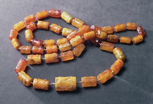 Halsketting van 49 cilindrische kralen versierd in bas-reliëf, ca. 1600 (amber)