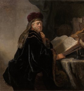 Een geleerde zittend aan een bureau door Rembrandt van Rijn