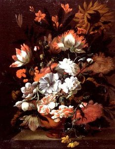 Tulpen, anjers, zonnebloemen en andere bloemen in een urn op een stenen richel