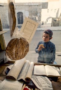 Conservatieve Joodse jongen eet cake en kijkt in een religieuze boekwinkel door Ted Spiegel
