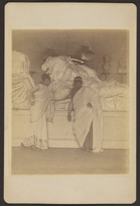 [Twee mannelijke studenten in Griekse kleding voor een gipsafgietsel van de drie lotgevallen van de Elgin Marbles].