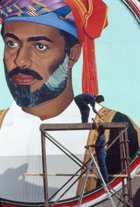Arbeiders onderhouden een gigantische muurschildering van Qaboos bin Said Al Said, Sultan van Oman