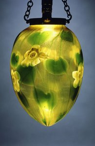 Een hangende lantaarn, versierd met groene bladeren en wijnstokken en gele iriserende bloemen