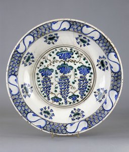 Een Iznik aardewerkschotel, met een centraal rondel met drie trossen druiven en wijnbladeren, ca.1570 door Turkish School