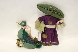 Miss Green Peas lappenpop, hoofd is in de vorm van een erwtenschil, en ze leidt haar huisdier eend aan een roze satijnen lint