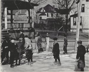 Een groep jongens in winterjassen die op een onbekende straat staan, voor of na een schooldag.