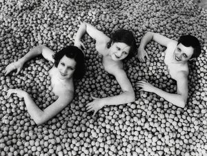 Drie jonge vrouwen baden in een zee van walnoten door Unbekannt