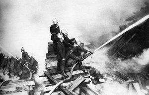 Brandweermannen bestrijden een brand in een houtwerf, Londen