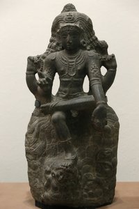 Het Victoria en Albert Museum. Shiva als Dakshinamurti. 1200-1300. Late Chola periode. Graniet. Zuid-India (Tamil Nadu). Verenigd Koninkrijk