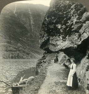 Waar de weg onder de uitstekende kliffen door kruipt bij de wateren van de Nerofjord, Noorwegen, ca. 1905 door Unbekannt