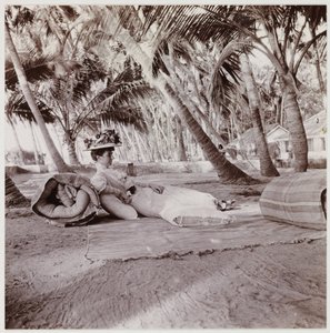 Vrouw liggend onder palmbomen, circa 1911