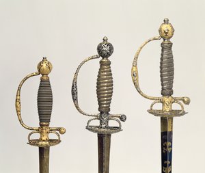 Heften van drie Franse zwaarden: een van staal, geblauwd en versierd met ontwerpen in gegraveerd goud, c.1730; een van staal, doorboord en gegraveerd en de grond van gematteerd goud, c.1760; een van gegraveerd staal