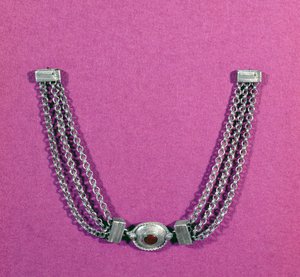 Zilveren ketting met een carneool, in een ovale setting omrand met een kabelrand, opgehangen tussen twee lengtes van drie kettingen vastgemaakt door een doosachtige sluiting, gevonden in Great Chesters, midden 1e tot door Unbekannt Unbekannt