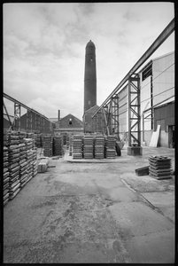 Een algemeen zicht op de Elswick Shot Tower, gesloopt 1968-69, gebruikt voor het maken van loden kogels, met een werf met paletten op de voorgrond, ca. 1955-69 door Unbekannter Künstler