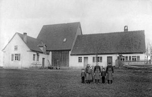 Familie van boeren poseert voor de boerderij.